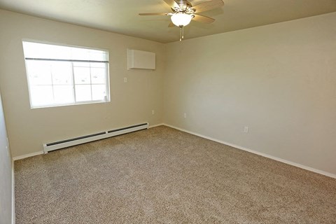 an empty room with a ceiling fan and a window