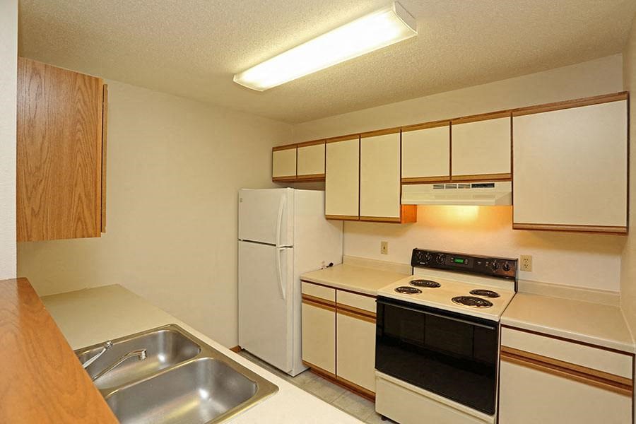 a kitchen with a stove refrigerator and a sink