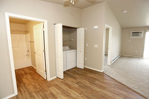 A room with a white door and a brown floor.