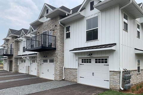 a row of white houses with white garage doors