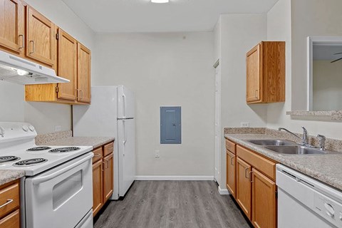 A kitchen with white appliances and wooden cabinets.