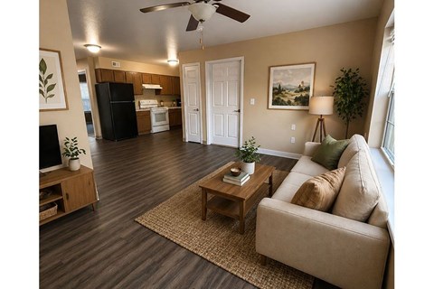 A living room with a couch, a coffee table, and a ceiling fan.