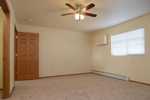 an empty room with a ceiling fan and a door
