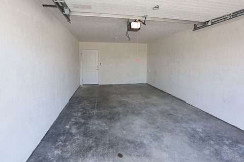 an empty garage with a white wall and a door
