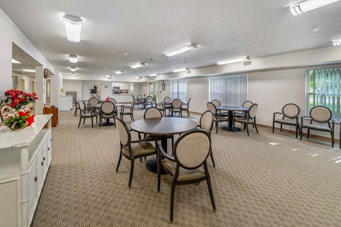 A dining room with a round table and chairs.