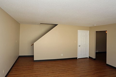 A room with a white door and a staircase.