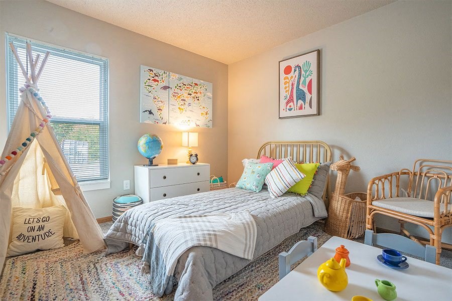 a bedroom with a bed and a dresser and a window