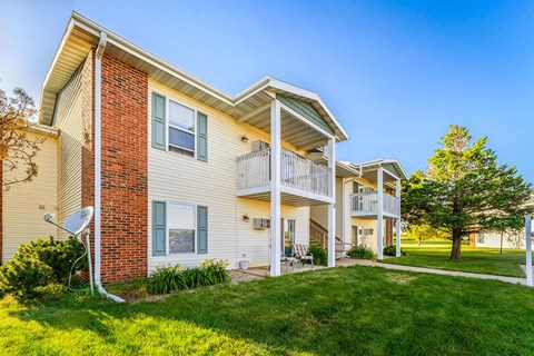A two-story apartment building with a balcony on the second floor.