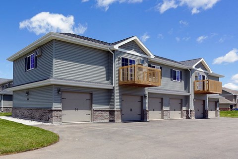 a blue house with garage doors and a balcony