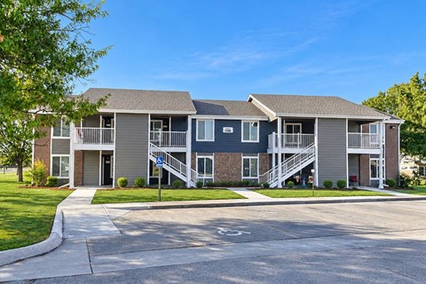 A two-story apartment building with a driveway in front.