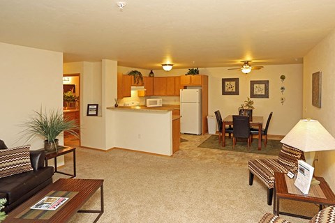 A living room with a couch, coffee table, and a dining table.