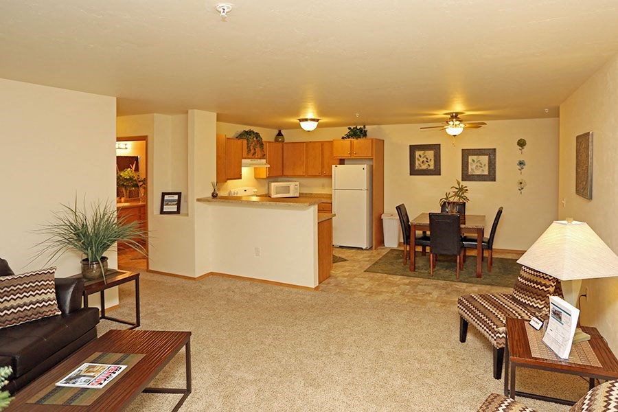 A living room with a couch, coffee table, and a dining table.