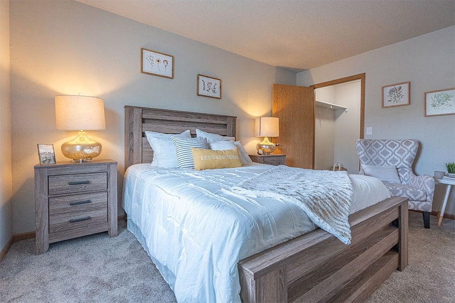 a bedroom with a bed and a dresser and a mirror