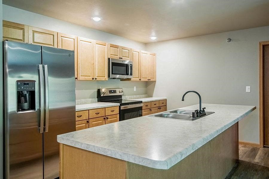 a kitchen with stainless steel appliances and a marble counter top