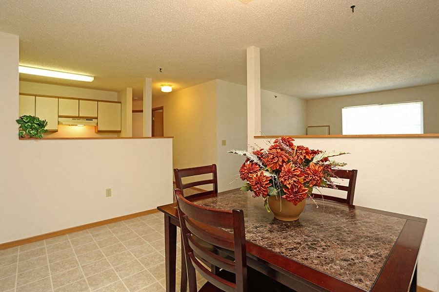 a dining room table with a vase of flowers