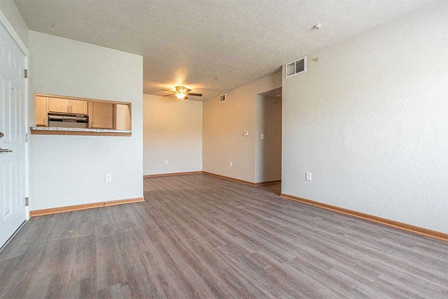 an empty living room with a kitchen in it