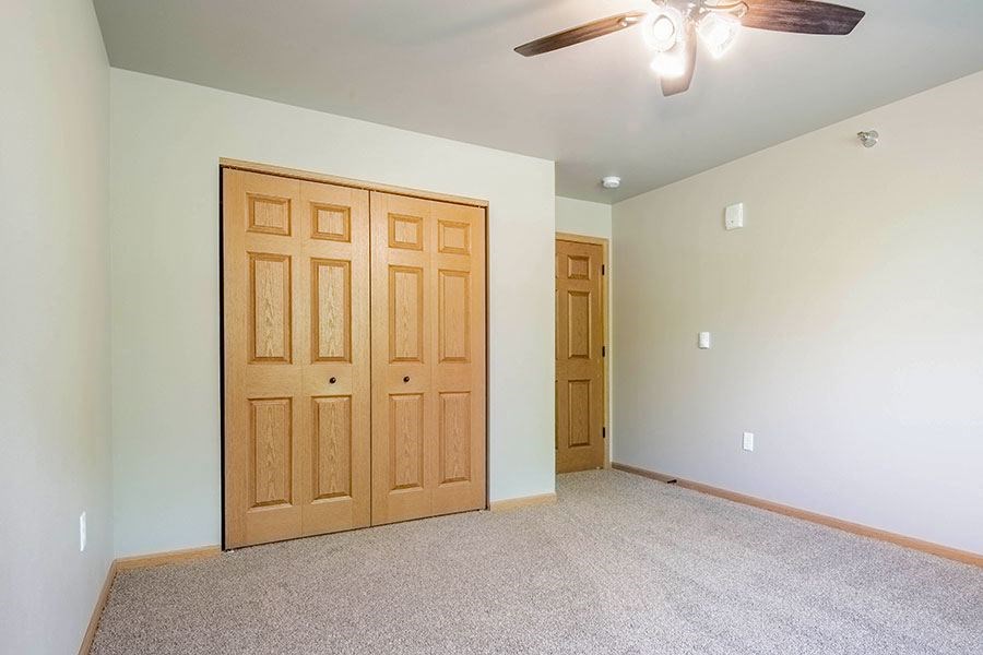 a empty room with a ceiling fan and a door