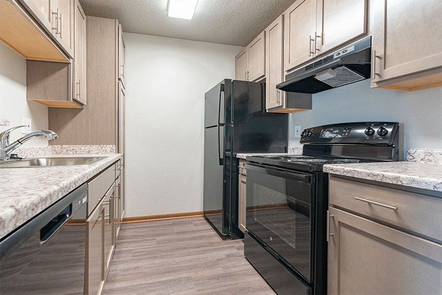 a kitchen with a stove refrigerator and sink