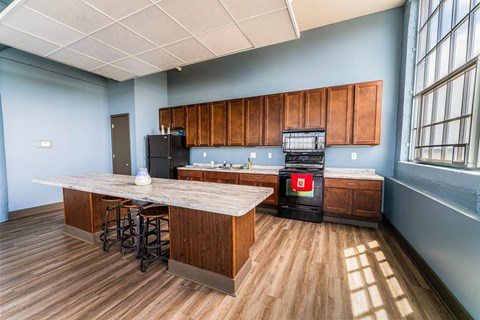 A kitchen with wooden cabinets and a black fridge.