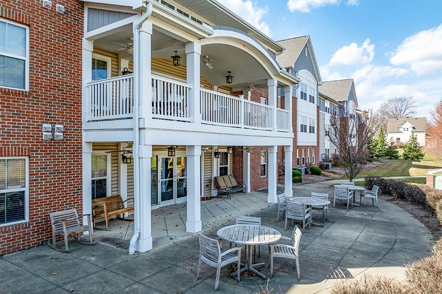 A patio with a table and chairs is in front of a brick building.