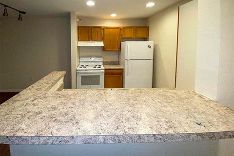an empty kitchen with a counter and a refrigerator