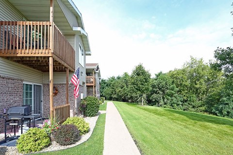 a yard in front of a house with a lawn and a flag