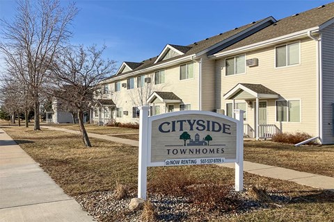 a citywide town homes sign in front of a row of houses