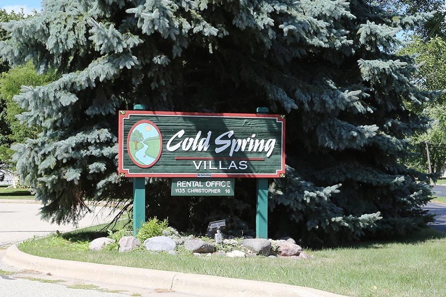 a sign for cold spring villas in front of some trees