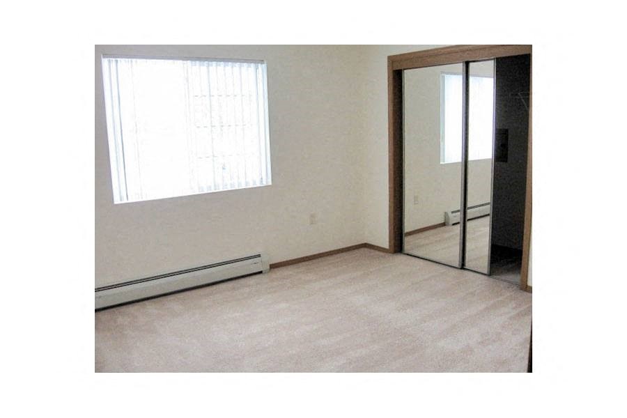 an empty room with a window and a mirror