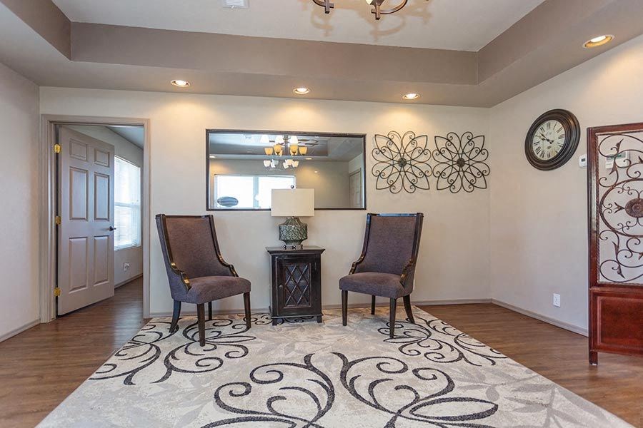 a living room with two chairs and a clock on the wall