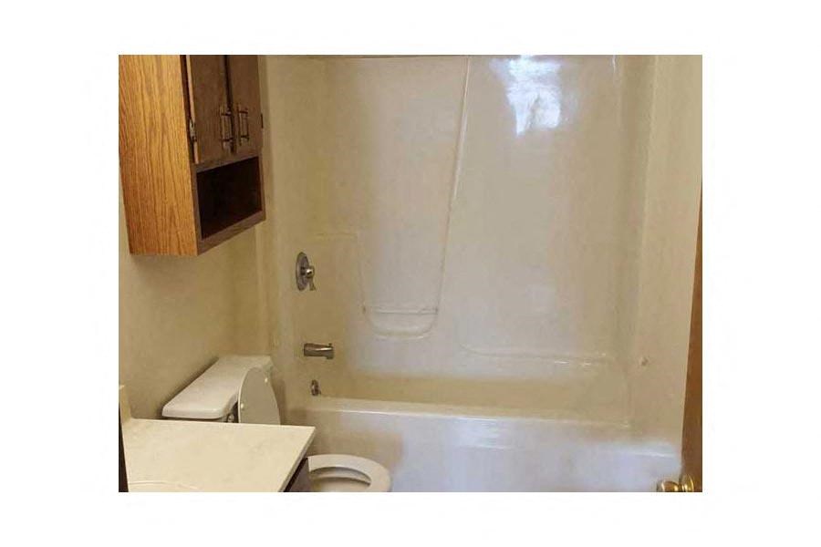 a white bathroom with a toilet and a shower