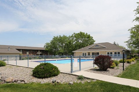 a swimming pool with a fence in front of a house