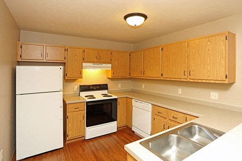 a kitchen with white appliances and wooden cabinets