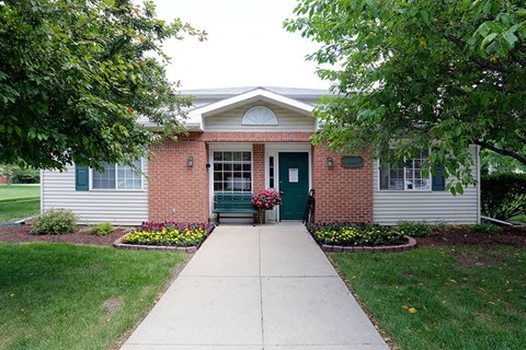 a small white house with a sidewalk in front of it