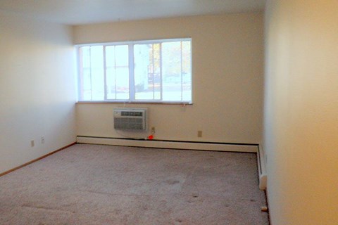an empty room with a radiator and a window
