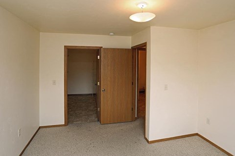 an empty living room with a door to a hallway