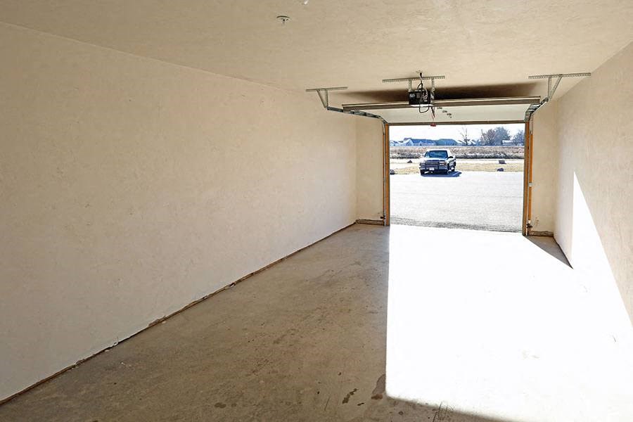 the inside of a garage with a car in the door