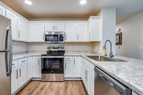 A kitchen with white cabinets and stainless steel appliances.