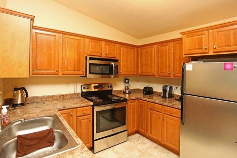 a kitchen with stainless steel appliances and wooden cabinets