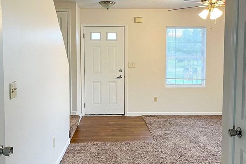 an empty room with a white door and a window