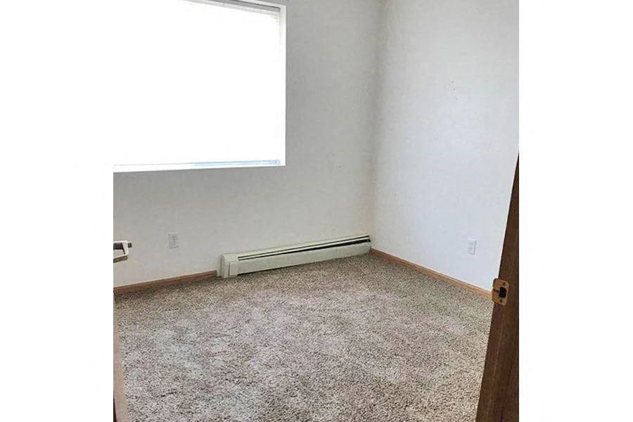 an empty room with a window and a carpet