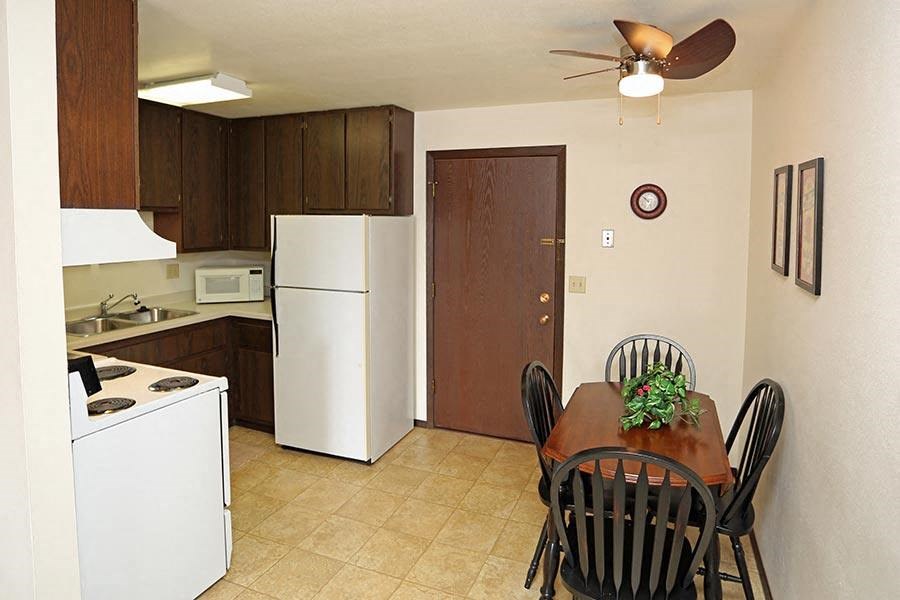 a kitchen with a dining table and a refrigerator