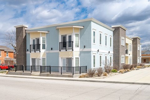 A row of modern townhouses with black fences in front.