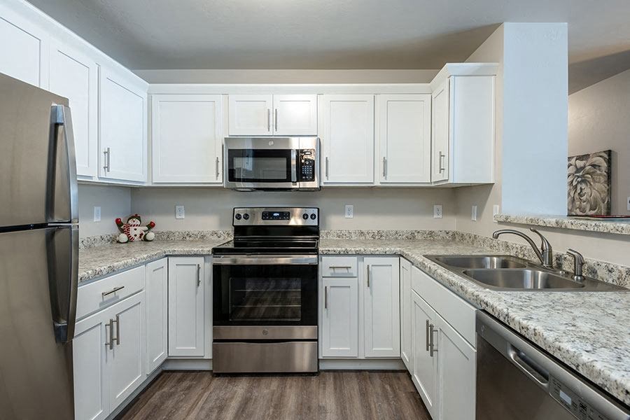 a kitchen with white cabinets and stainless steel appliances