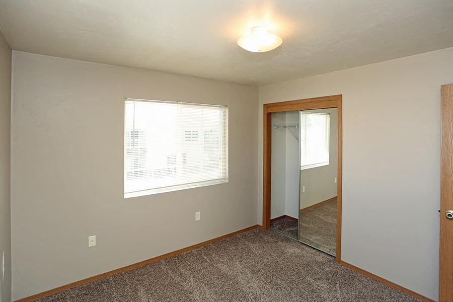 an empty room with a large window and a mirror