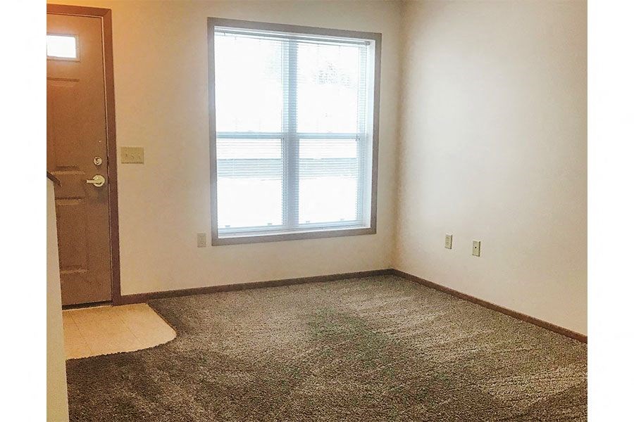 an empty room with a window and a door