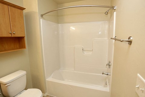 a white bathroom with a toilet and a shower