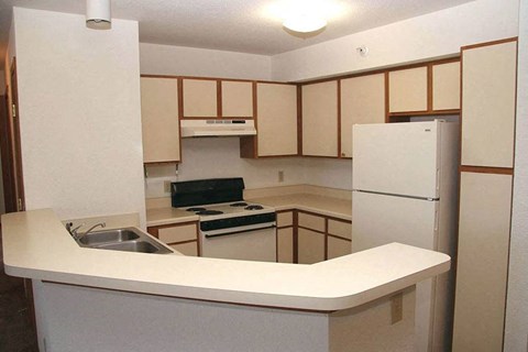 an empty kitchen with a stove and a refrigerator