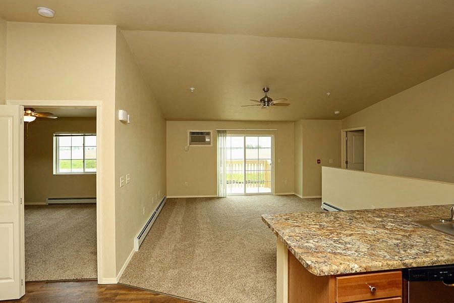 an empty living room with a granite counter top