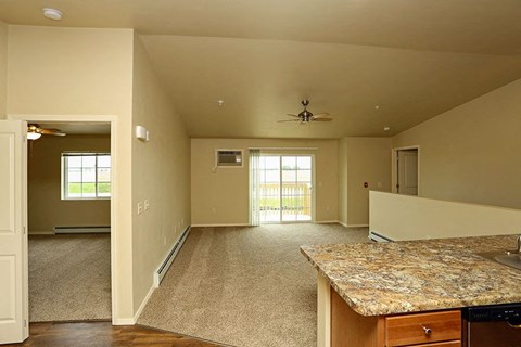 an empty living room with a granite counter top